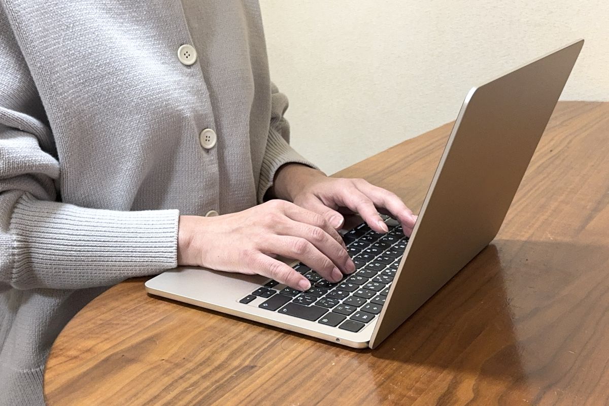 ノートパソコンで記事を執筆する手元