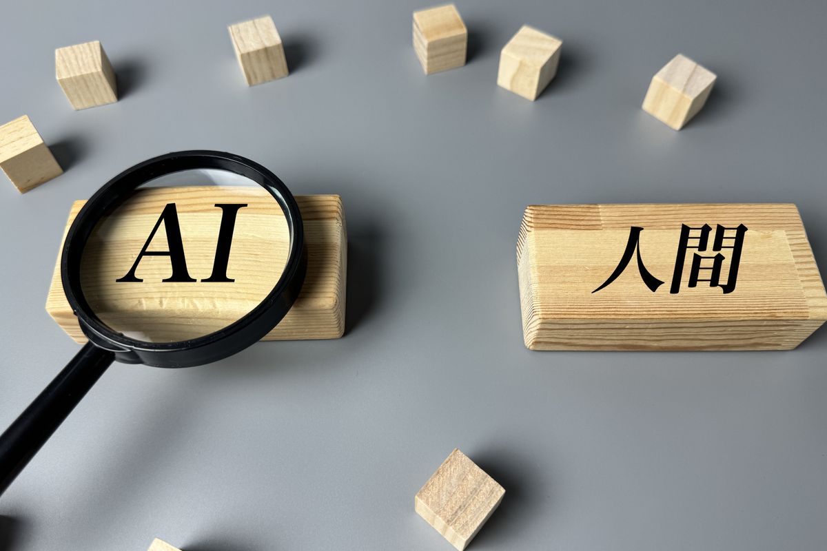 AIと人間の文字を虫眼鏡で見比べるイメージ