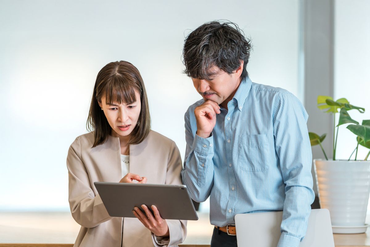 タブレットを見ながら相談する二人